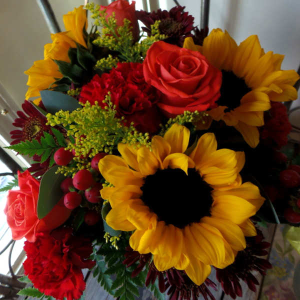 Bouquet of sunflowers, red roses, and burgundy daisies