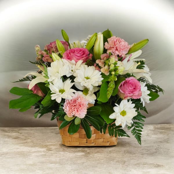Pink roses and white daisies in a woven basket