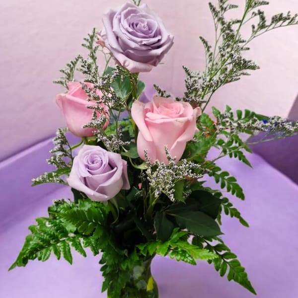 Lavender and pink roses arranged in a glass vase