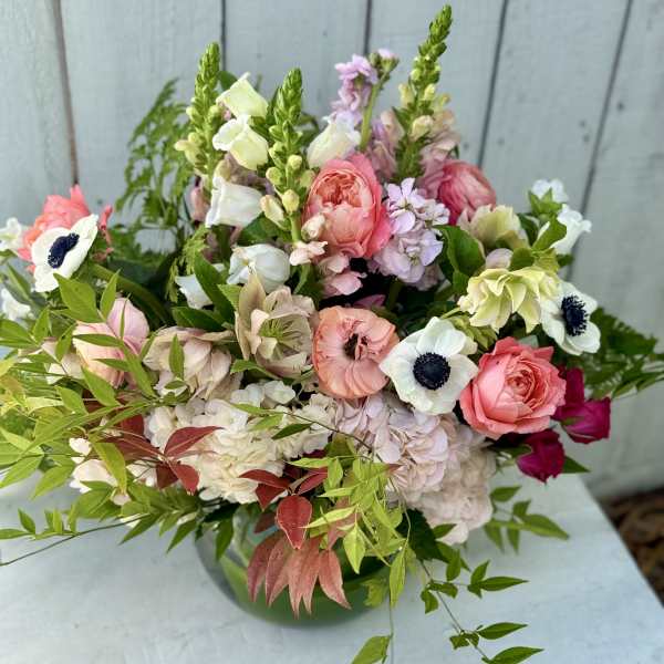Mixed pink and white bouquet with anemones and roses in a vase
