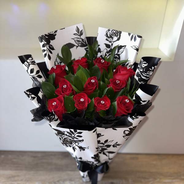 Bouquet of red roses wrapped in black-and-white paper