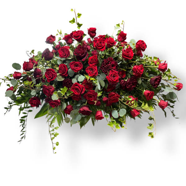 Large arrangement of red roses with greenery on a white background