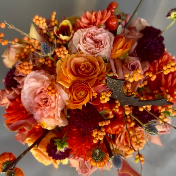 Autumn bouquet with orange and pink roses, dahlias, and berry accents