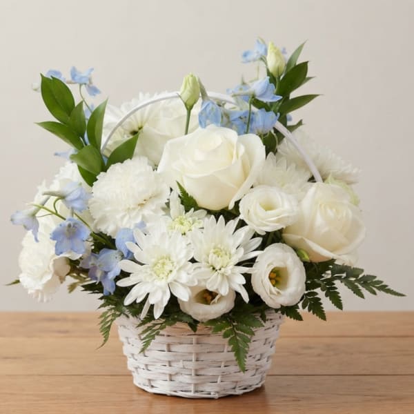 White and pale blue floral arrangement in a white basket