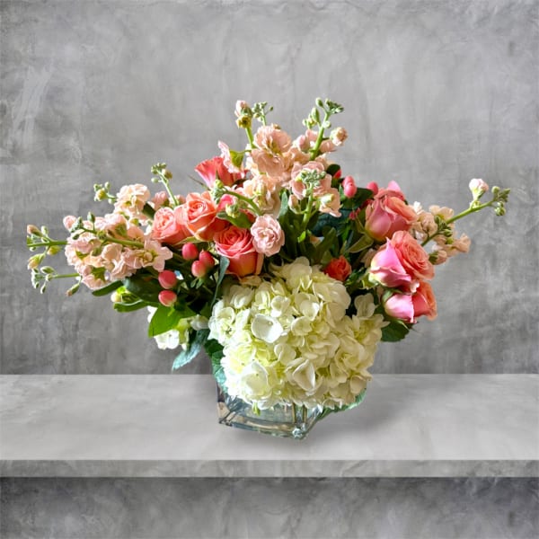Pink roses and white hydrangeas arranged in a glass vase