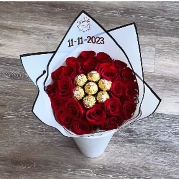 Bouquet of red roses with gold-wrapped chocolates in white paper