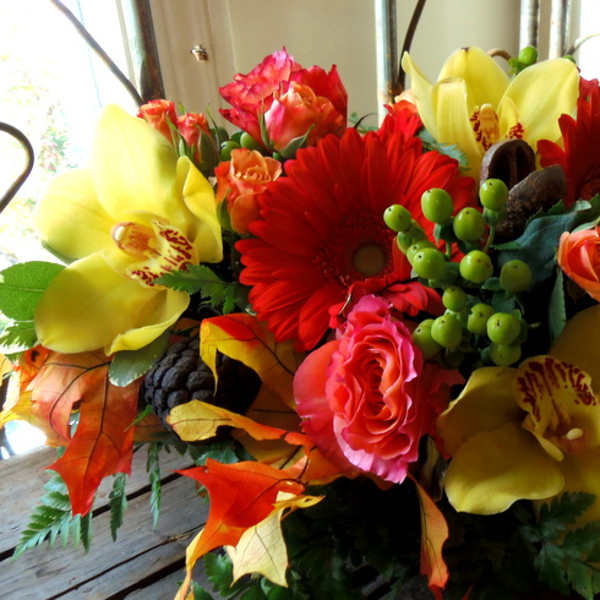 Bouquet of red gerbera daisies, pink roses, and yellow orchids