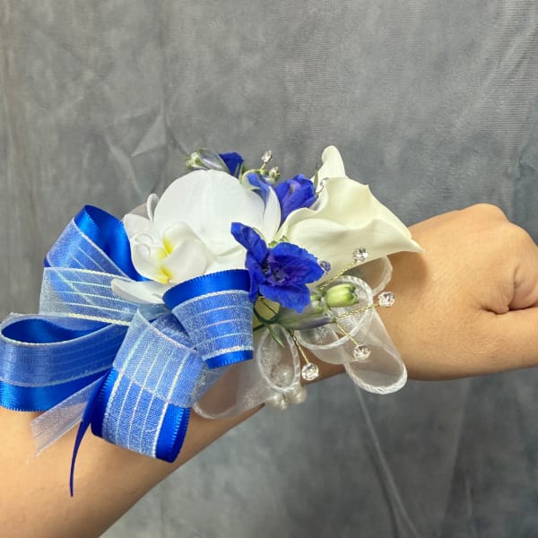 Blue and white wrist corsage with ribbon and small flowers