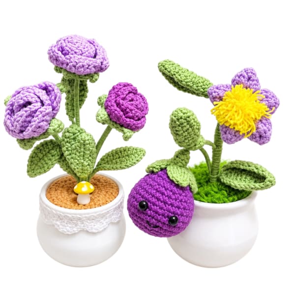 Crocheted purple flowers in white pots with a small mushroom and berry decoration