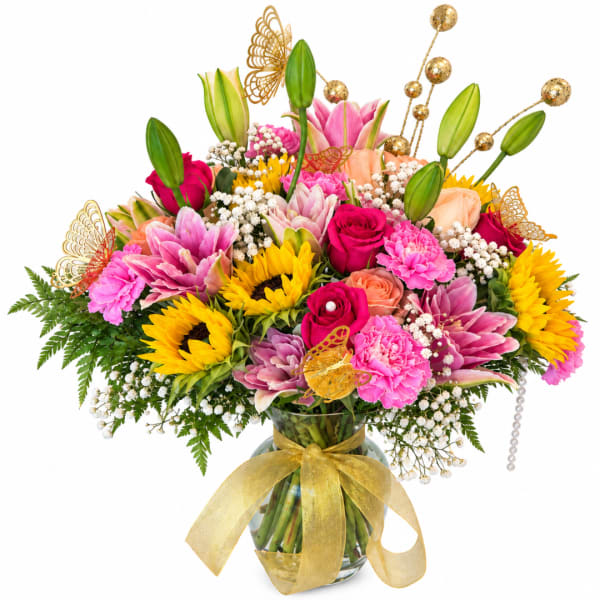Bright mixed bouquet in a glass vase with a gold ribbon