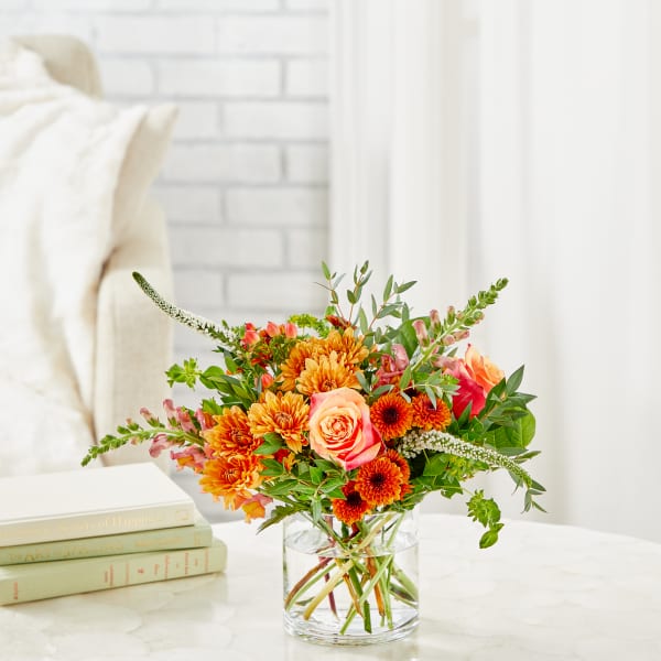 Orange and peach mixed bouquet in a clear glass vase