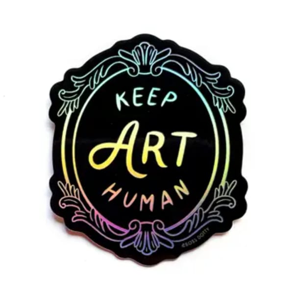 Round black sign with colorful text reading Keep Art Human