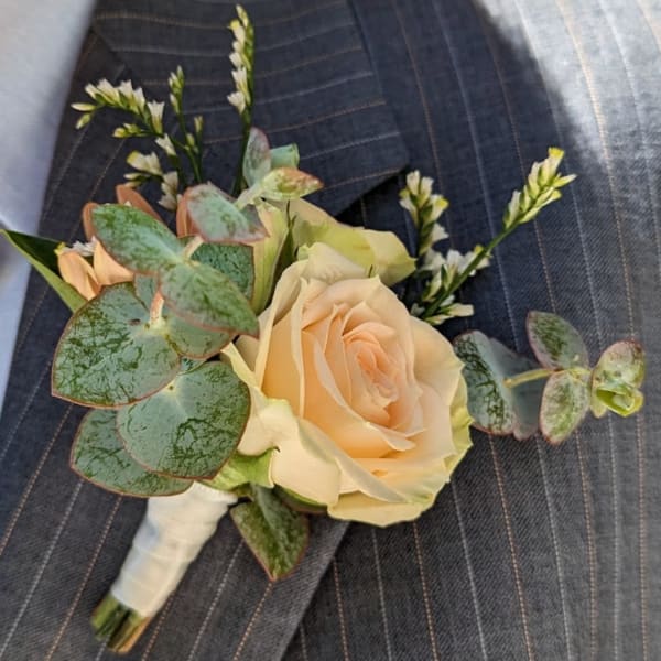 Peach rose boutonniere with eucalyptus and small white accents