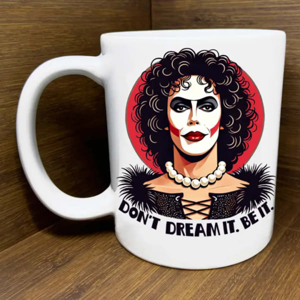 White mug with a graphic portrait and the text "DON'T DREAM IT. BE IT."