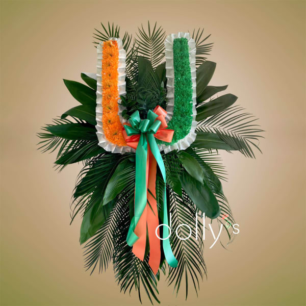 Floral standing tribute with orange and green U-shaped garlands and ribbon bow