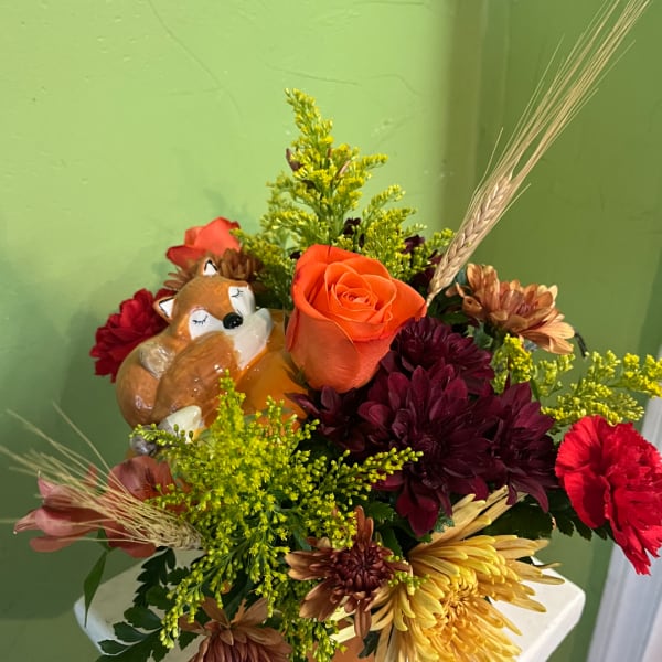 Mixed flower bouquet with a fox figurine and wheat stems