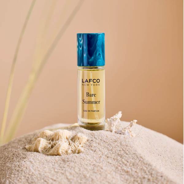 Bottle of LAFCO New York Bare Summer perfume on sand with seashells