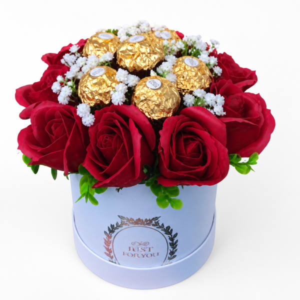 Red roses with gold-wrapped chocolates in a white hat box
