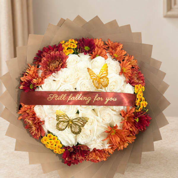 Round bouquet of white roses with orange and burgundy chrysanthemums