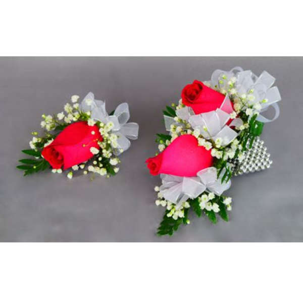 Two rose corsages with white ribbon and baby's breath