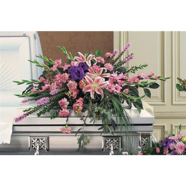 Large pink and purple floral spray on a silver casket