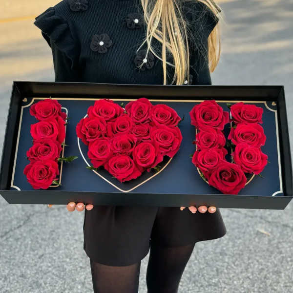 Red roses arranged to spell "I LOVE U" in a black box