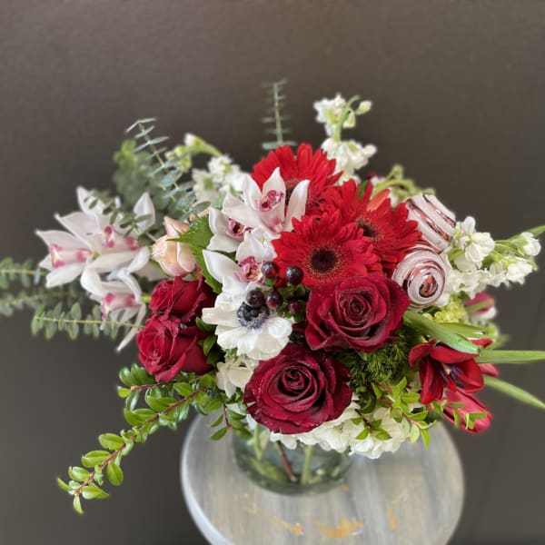 Red and white mixed flower bouquet in a glass vase