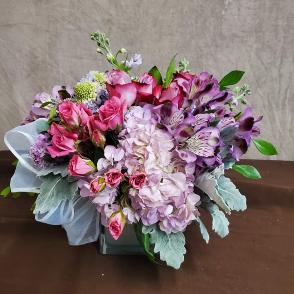 Pink and lavender bouquet with roses, hydrangea, and alstroemeria in a square vase
