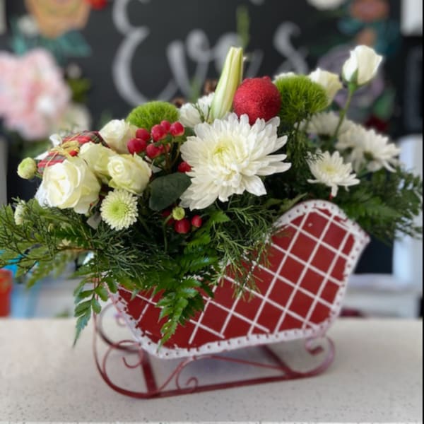 White and red floral arrangement in a heart-shaped red container