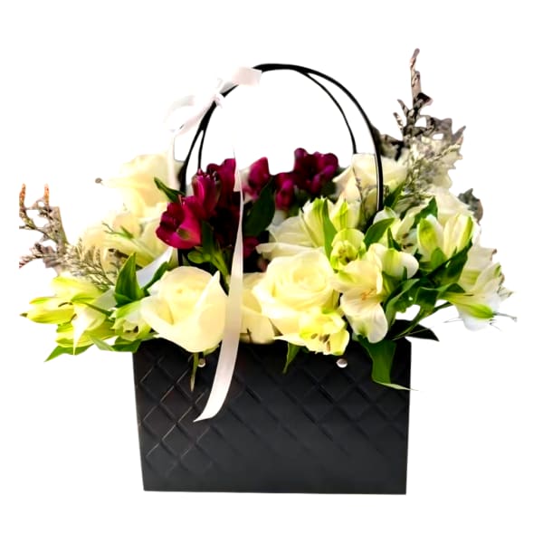 Flower arrangement in a black handled basket with white and burgundy blooms