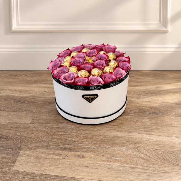 Pink roses and gold chocolates arranged in a white round box