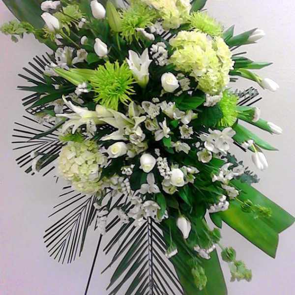 Standing floral spray with white and green flowers on an easel