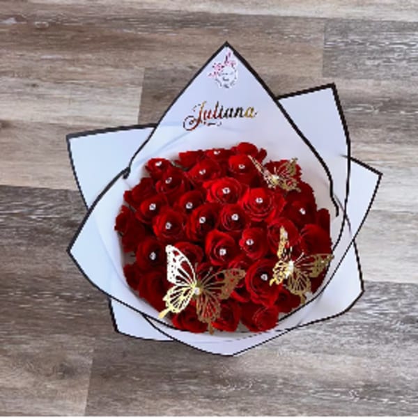 Bouquet of red roses wrapped in white paper with butterfly accents