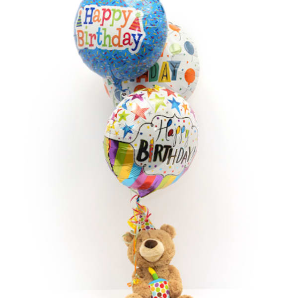 Birthday balloons with a teddy bear holding a party horn