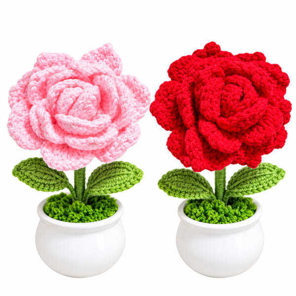 Two crocheted flowers in white pots, one pink and one red