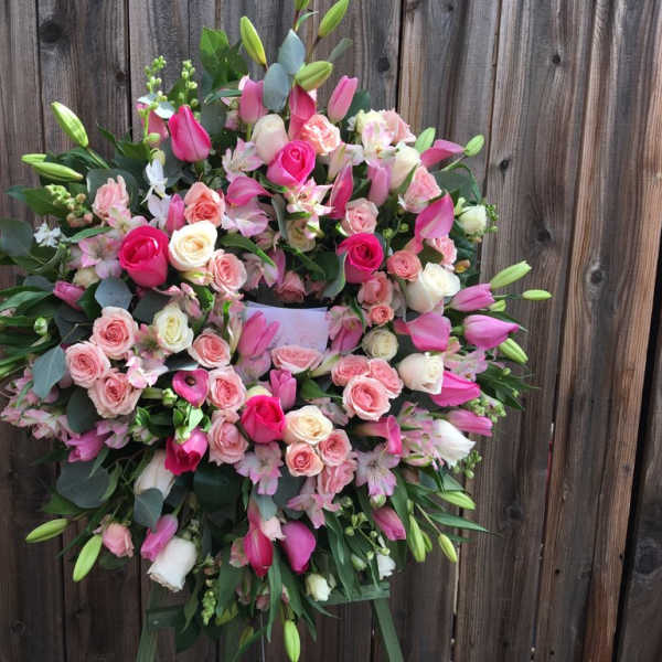 Large pink and white floral wreath on a stand