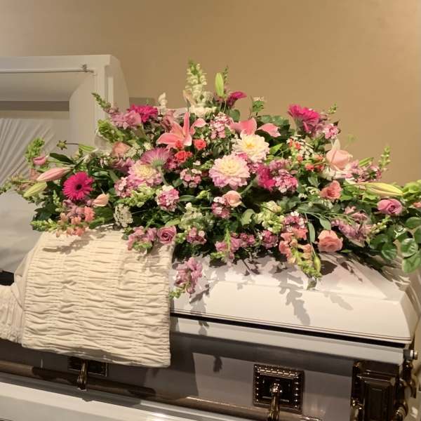 Large pink and white floral spray on a casket