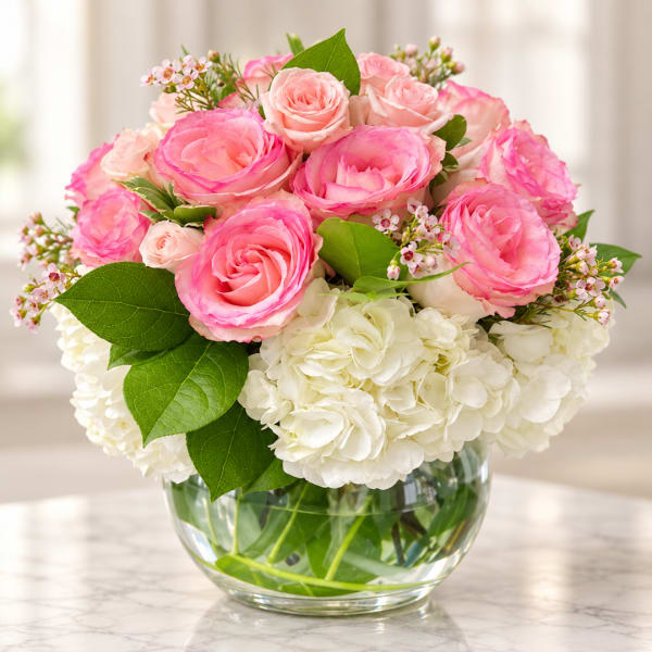 Pink roses and white hydrangeas in a clear glass vase