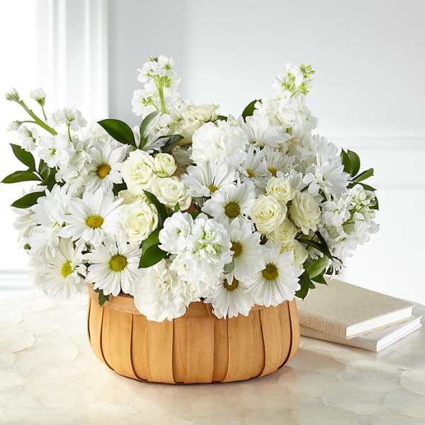 White daisies and roses arranged in a wooden basket