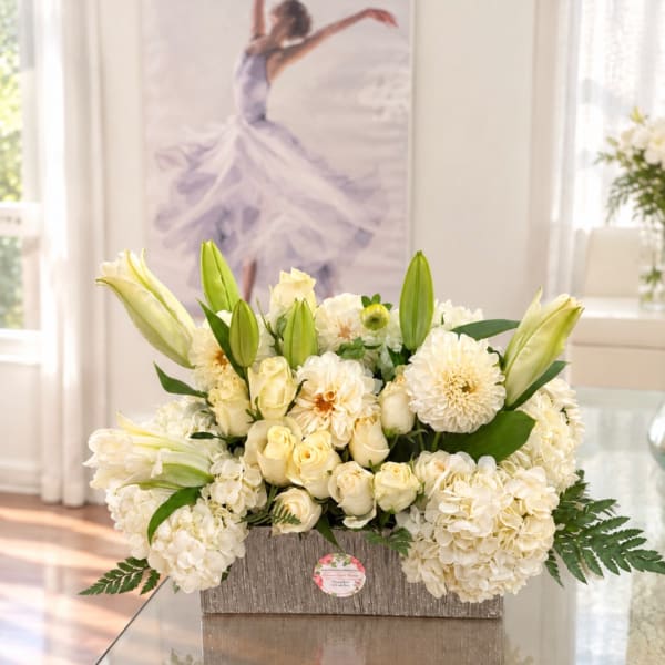 Cream floral arrangement in a textured rectangular container