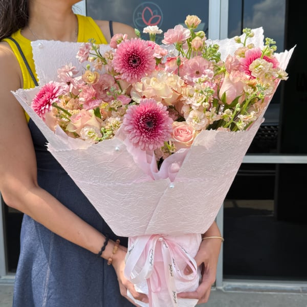 Pink and cream bouquet wrapped in pale pink paper