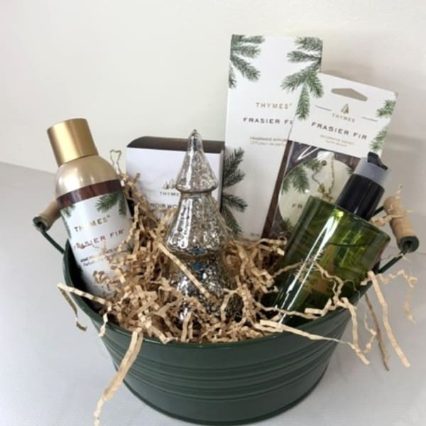 Holiday gift basket with pine-scented bath products and a small decorative tree