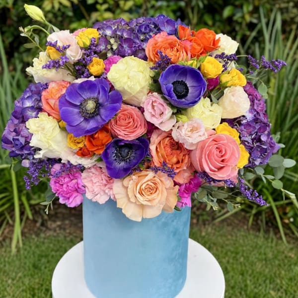 Colorful mixed bouquet in a light blue cylindrical vase