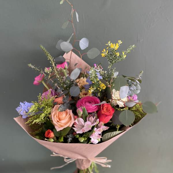 Hand-tied bouquet of mixed pink, peach, and purple flowers