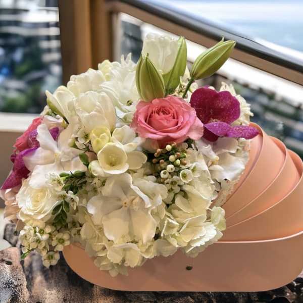 Pink and white bouquet in a peach hatbox with lilies and roses