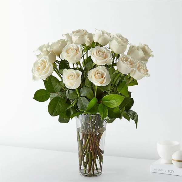 White roses arranged in a clear glass vase