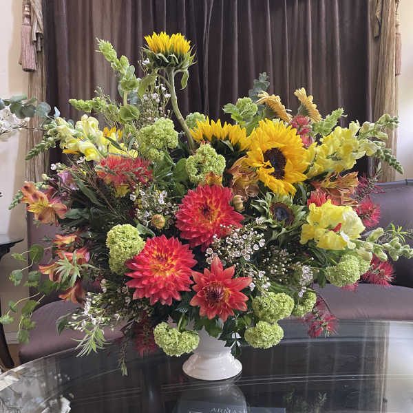 Large mixed bouquet with sunflowers, dahlias, and snapdragons in a white vase
