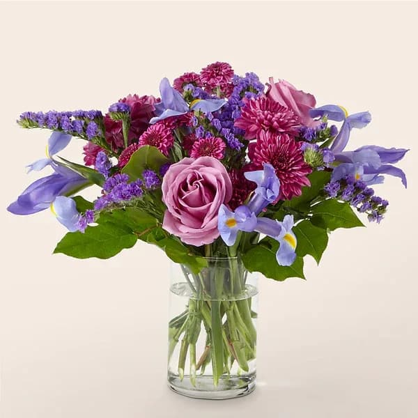 Purple and pink mixed bouquet in a clear glass vase