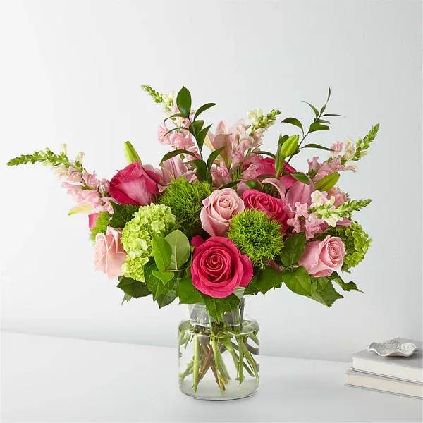 Pink roses and lilies in a clear glass vase