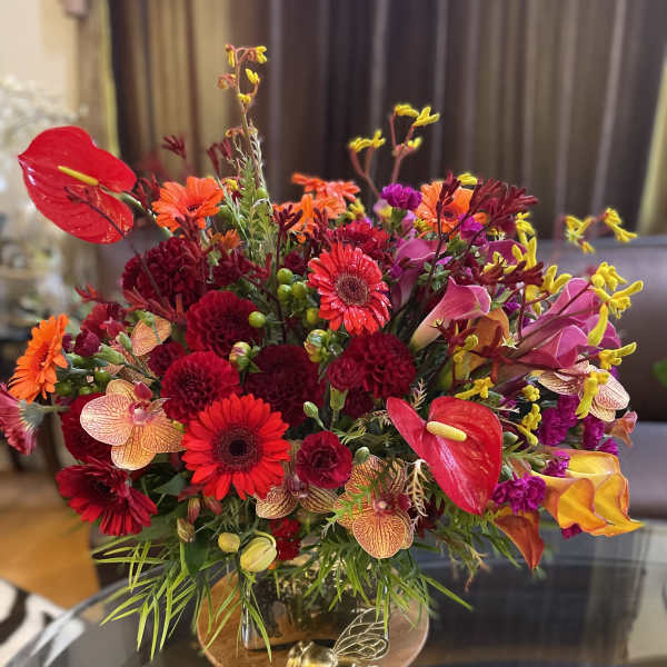 Bright mixed bouquet with red, orange, pink, and yellow flowers in a vase